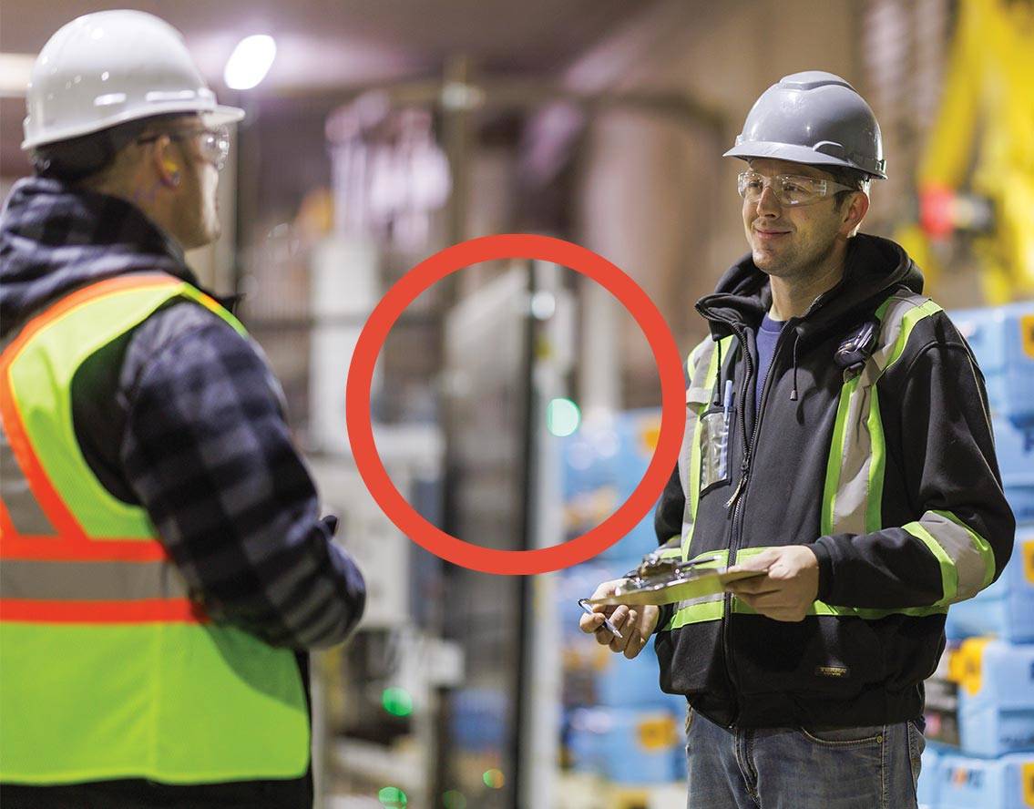 Two team members talking in a manufacturing facility